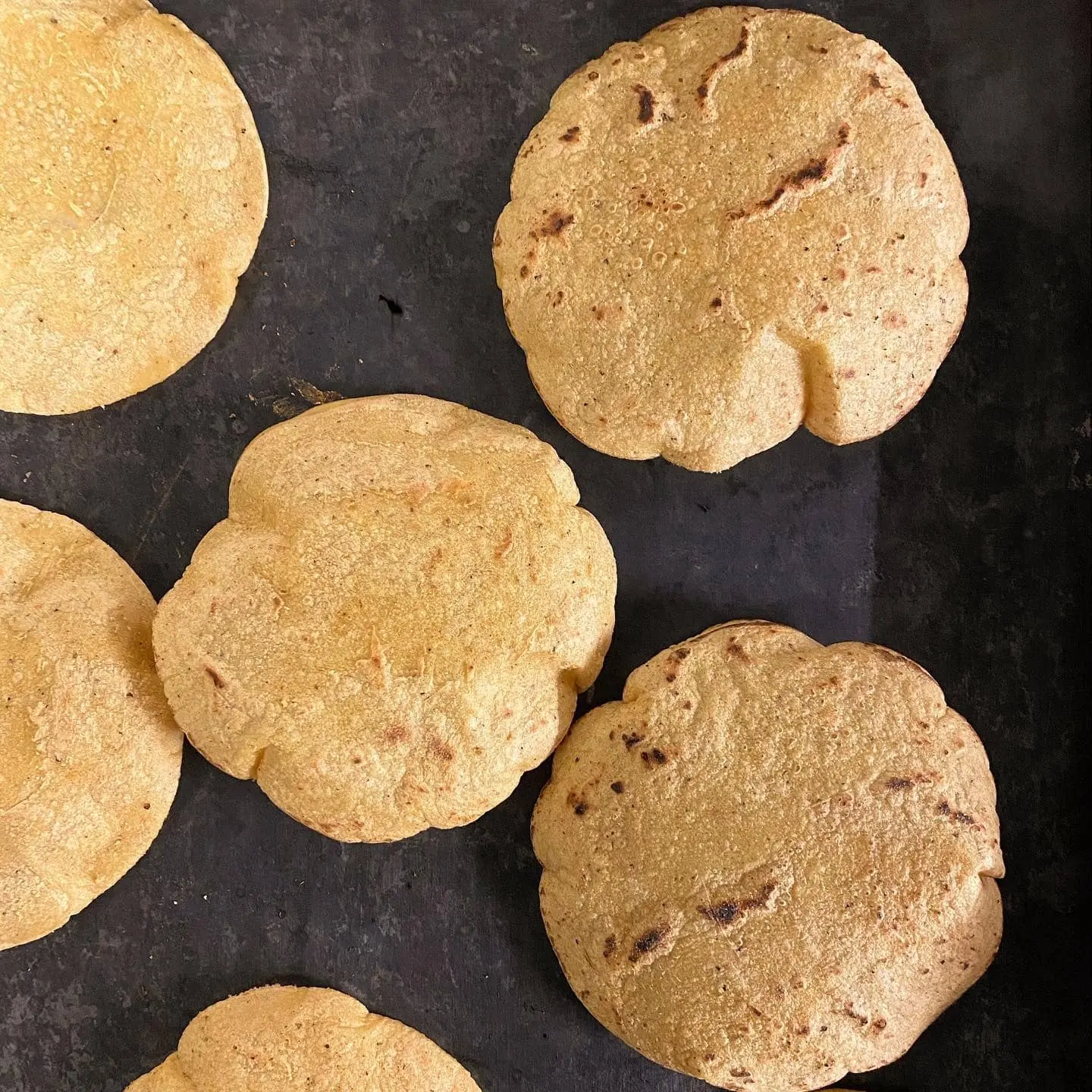 Tortilla groase din masa, rumenite pe un comal negru